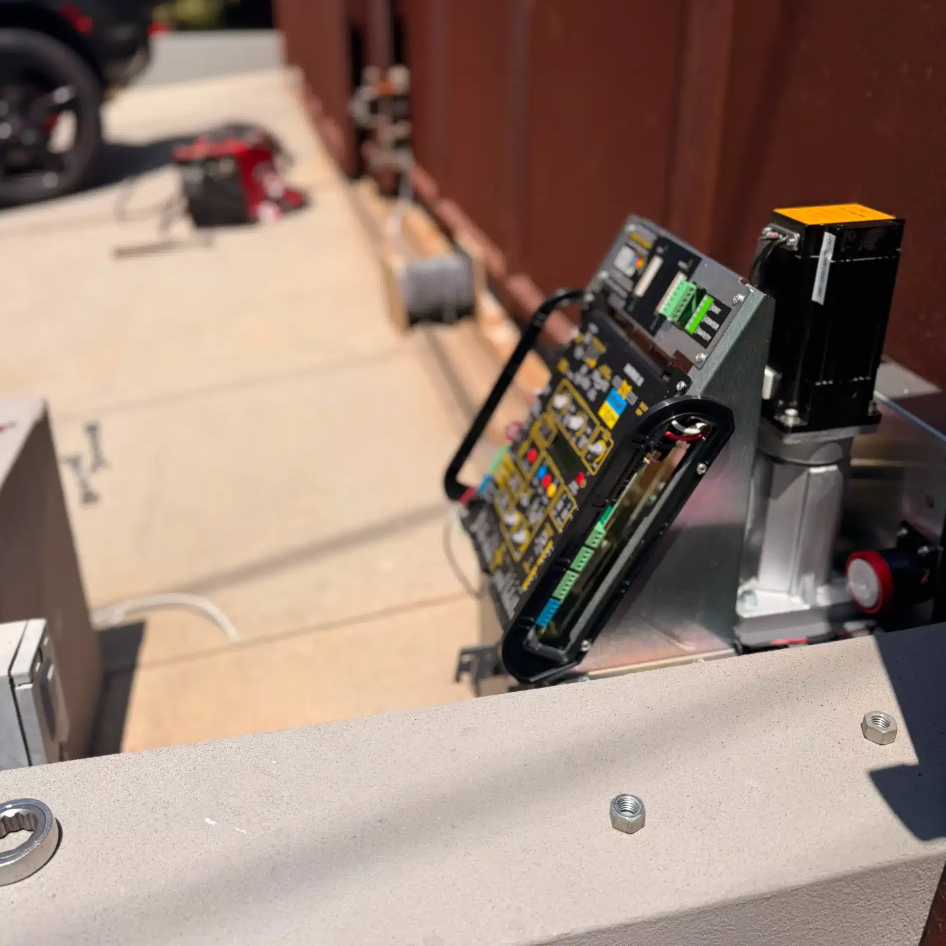 Automatic gate repair technician servicing a driveway gate in Newport Beach