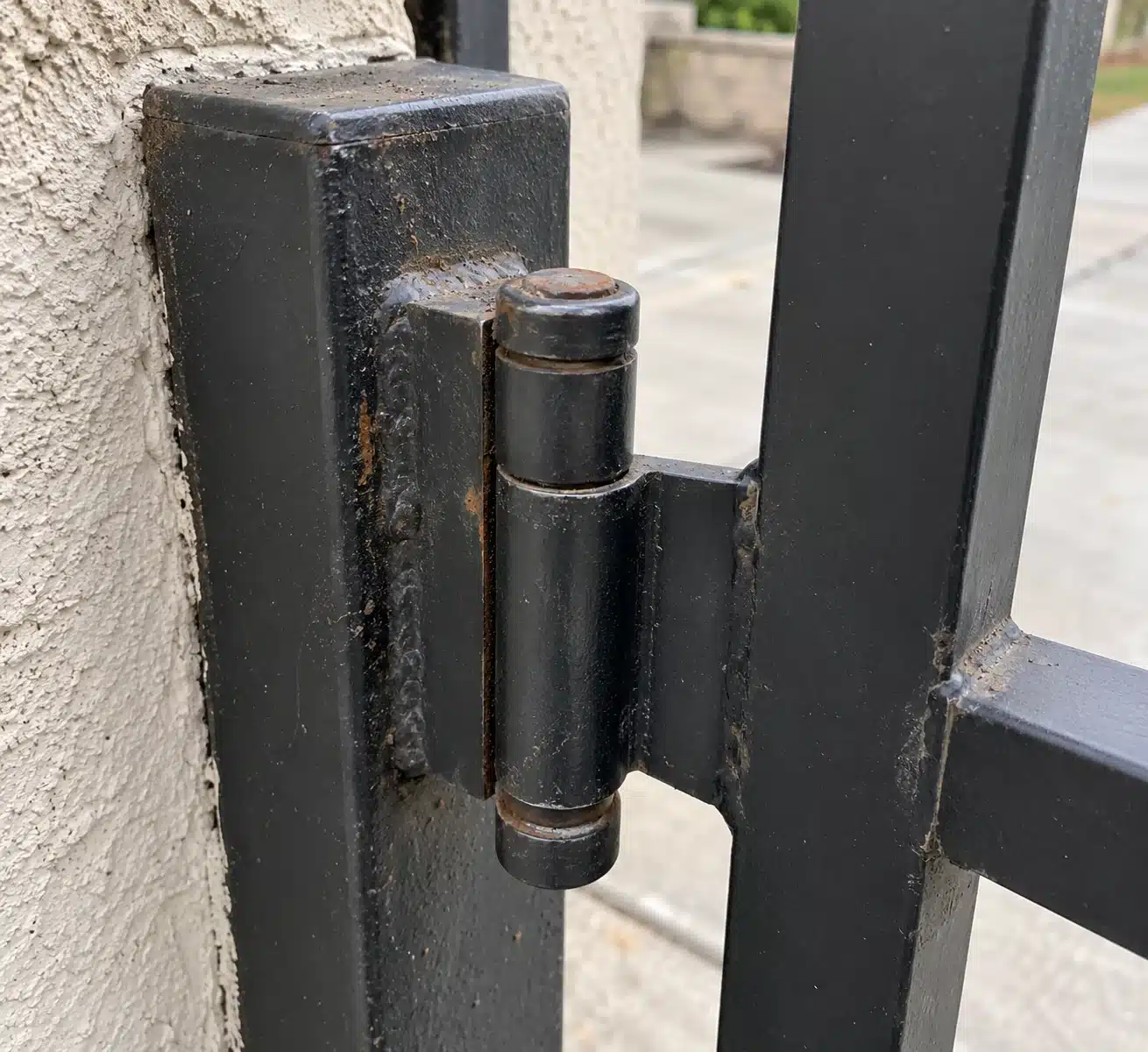 Swing gate hinge and opener arm on a residential driveway near Agoura Hills